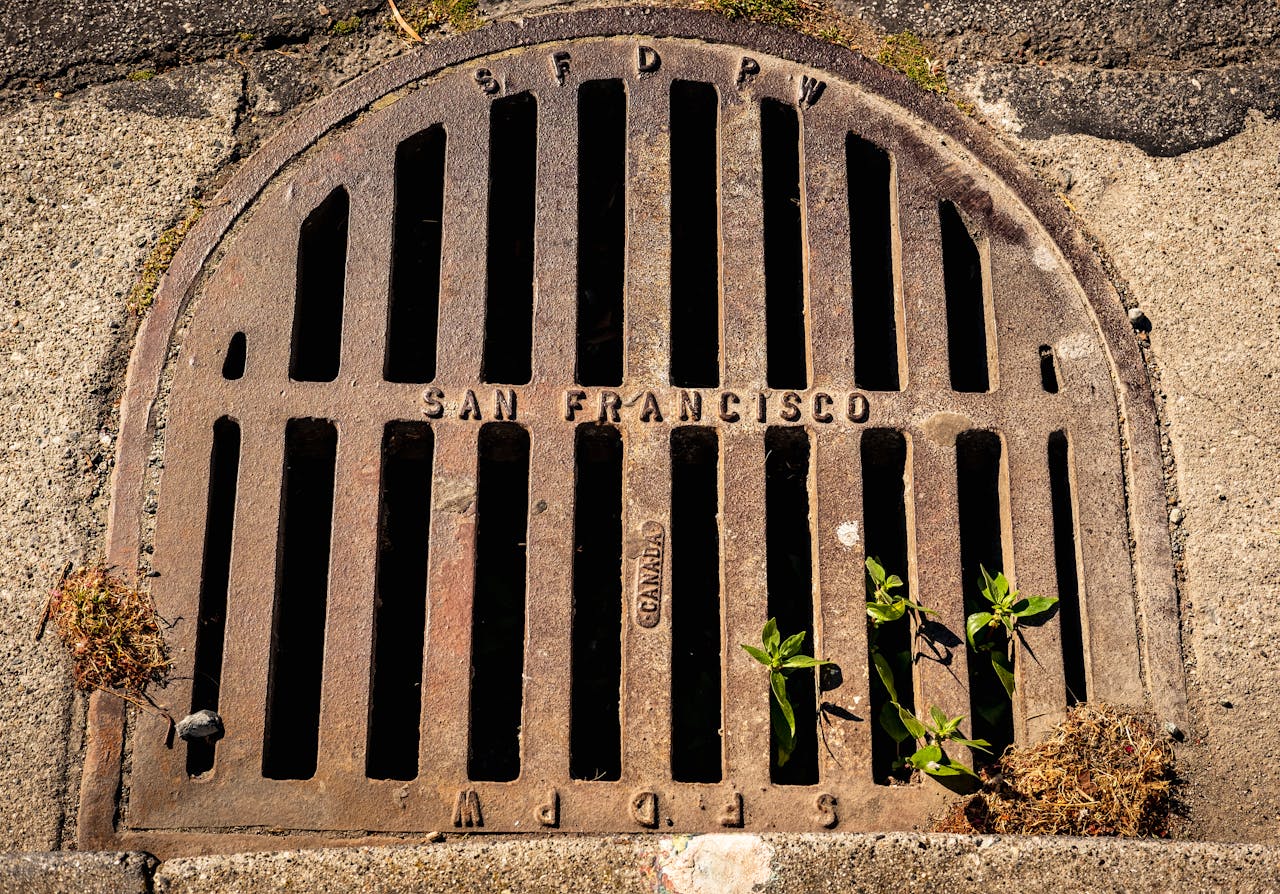 Close-up photo of a weathered drain cover embossed with San Francisco, showcasing urban texture and detail.